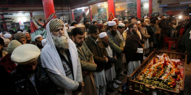 Mourners and relatives of Pakistani teacher, Saeed Khan, a victim of a Taliban attack in a school, pray around his body, during his funeral procession in Peshawar, Pakistan, Tuesday, Dec. 16, 2014. Taliban gunmen stormed a military-run school in the northwestern Pakistani city of Peshawar on Tuesday, killing at least 100 people, mostly children, before Pakistani officials declared a military operation to clear the school over. (AP Photo/Mohammad Sajjad)