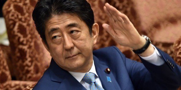 Japan's Prime Minister Shinzo Abe raises his hand to answer a question by an opposition lawmaker during an Upper House budget committee session at the National Diet in Tokyo on August 10, 2015. The Japanese public broadcaster reported on August 10 that a draft of Abe's statement to mark the 70th anniversary of the end of World War II includes the word 'apology'. The closely-watched remarks -- expected on August 14 -- will be heavily scrutinised by China and Korea, which dispute Tokyo's version of its wartime history and who are waiting to see if Abe repeats earlier apologies for Japan's militarism in the 20th century. AFP PHOTO / Yoshikazu TSUNO (Photo credit should read YOSHIKAZU TSUNO/AFP/Getty Images)