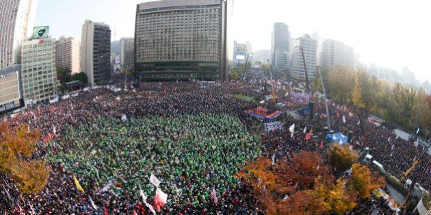 In this photo made with a fish-eye lens, South Korean people shout slogans during a protest against South Korean President Park Geun-hye on a main street in Seoul, South Korea Saturday, Nov. 12, 2016. Tens, and possibly hundreds, of thousands of South Koreans were expected to rally in Seoul on Saturday demanding the ouster of President Park in what would be one of the biggest protests in the country since its democratization about 30 years ago. (Jeon Heon-kyun/Pool Photo via AP)
