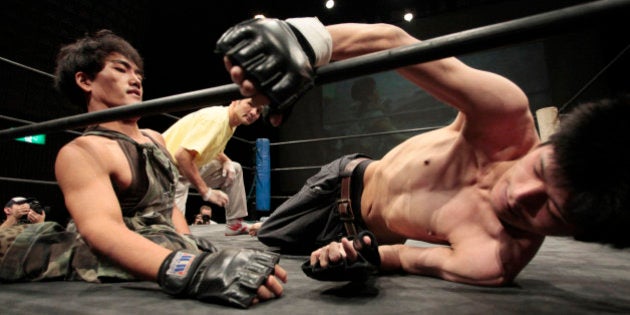 TO GO WITH AFP STORY JAPAN-SOCIETY-DISABLED-WRESTLING,FEATURE by Harumi OzawaIn a picture taken on October 8, 2011, wrestler Makoto Tsuruzono (L), with disabled legs, fights against 'Chest Man' whose legs are also disabled during the handicapped pro-wrestling 'Doglegs' in Tokyo. The competition attracts contenders with a variety of challenges ranging from psychological problems to physically hadicapped. AFP PHOTO / Noboru HASHIMOTO (Photo credit should read NOBORU HASHIMOTO/AFP/Getty Images)