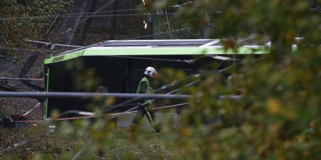 A member of the emergency services walks past a tram after it overturned injuring and trapping some passengers in Croydon, south London, Britain November 9, 2016. REUTERS/Neil Hall