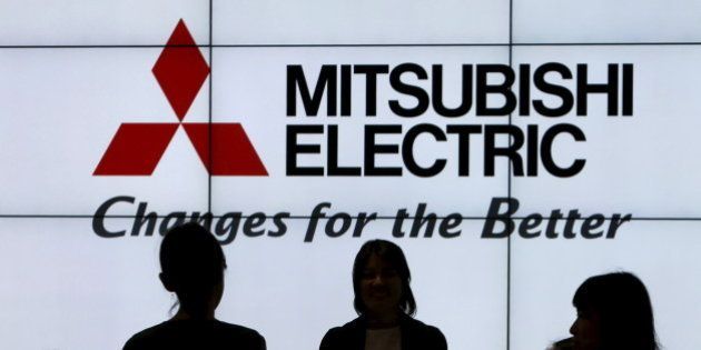 The company logo of Mitsubishi Electric is seen behind people at CEATEC (Combined Exhibition of Advanced Technologies) JAPAN 2015 in Makuhari, Japan, October 6, 2015. REUTERS/Yuya Shino