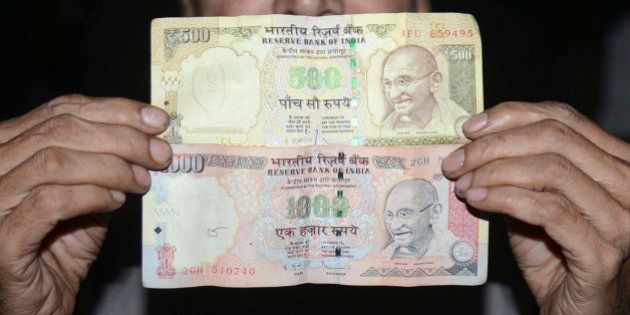 An Indian man holds 500 and 1000 INR notes in Amritsar on November 8, 2016. Indian Prime Minister Narendra Modi announced late November 8 that 500 and 1,000 ($15) rupee notes will be withdrawn from financial circulation from midnight, in a bid to tackle corruption. 'To break the grip of corruption and black money, we have decided that the 500 and 1,000 rupee currency notes presently in use will no longer be legal tender from midnight ie 8 November, 2016,' Modi said in a special televised address to the nation. / AFP / NARINDER NANU (Photo credit should read NARINDER NANU/AFP/Getty Images)