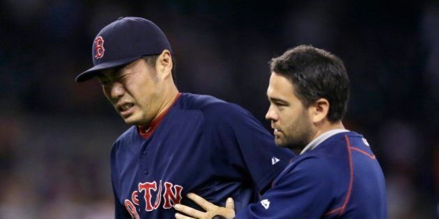 Boston Red Sox relief pitcher Koji Uehara is helped off the field after a baseball game against the Detroit Tigers, Friday, Aug. 7, 2015, in Detroit. Uehara was hit on a grounder by Tigers' Ian Kinsler. The Red Sox defeated the Tigers 7-2. (AP Photo/Carlos Osorio)