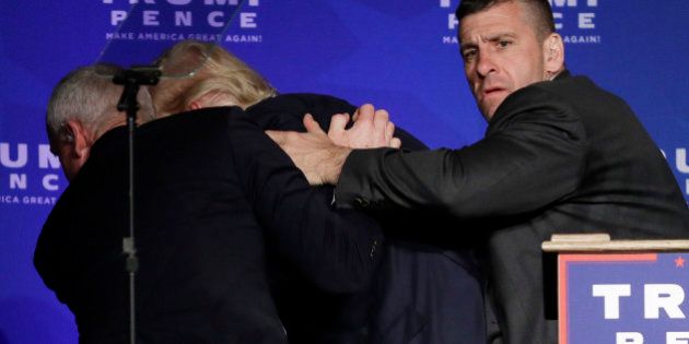 Secret Service agents rush Republican presidential candidate Donald Trump off the stage during a campaign rally in Reno, Nev., on Saturday, Nov. 5, 2016. He returned to the podium afterwards. (AP Photo/John Locher)