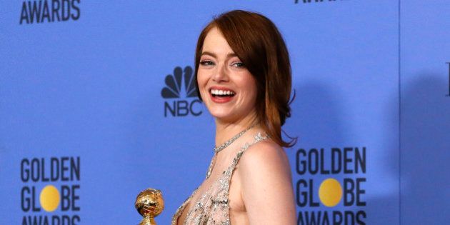 Emma Stone poses with her award for Best Performance by an Actress in a Motion Picture - Musical or Comedy for her role in