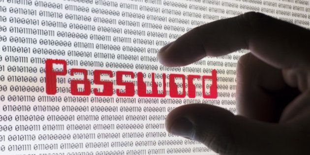 A male hand grabbing the word 'PASSWORD' on a computer screen with binary code.