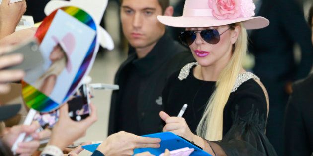 Lady Gaga gives her autographs to fans upon her arrival at Narita international airport in Narita, east of Tokyo, Tuesday, Nov. 1, 2016. (AP Photo/Shizuo Kambayashi)