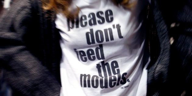 「モデルに食事を与えないで下さい」と書かれたTシャツを着るファッションモデル。やせすぎモデルを起用しない動きが広がる前は、問題が広く認識されない現状があった＝2007年のロンドンファッションウィークのショーで