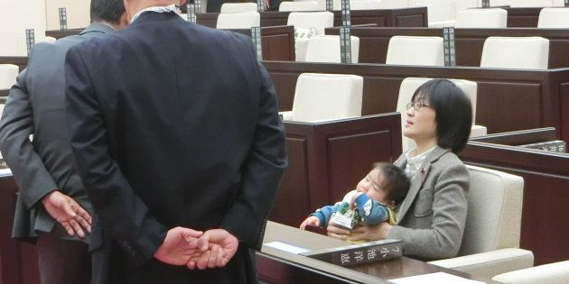 熊本市議会に生後７カ月の長男を抱いたまま出席し、議会事務局職員らによる退席要請を拒否する緒方夕佳議員（右）＝2017年11月22日、熊本市中央区