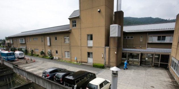 A police officer walks at the Tsukui Yamayuri-en, a facility for the mentally disabled where a number of people were killed and dozens injured in a knife attack in Sagamihara, outside of Tokyo, Wednesday, July 27, 2016. The suspect was being transferred Wednesday from a local police station to the prosecutor's office in Yokohama. (AP Photo/Shizuo Kambayashi)