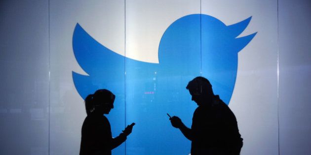 People are seen as silhouettes as they check mobile devices whilst standing against an illuminated wall bearing Twitter Inc.'s logo in this arranged photograph in London, U.K., on Tuesday, Jan. 5, 2016. Twitter Inc. may be preparing to raise its character limit for tweets to the thousands from the current 140, a person with knowledge of the matter said. Photographer: Chris Ratcliffe/Bloomberg via Getty Images