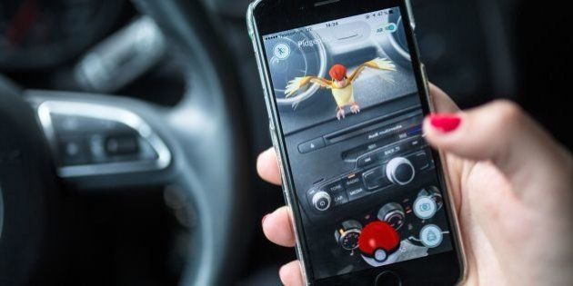 A woman plays the Pokemon Go mobile game on her smart phone in a car in Berlin on July 13, 2016.The Pokemon Go mobile gaming craze reached European fans with players in Germany the first to get their hands on the augmented reality sensation. / AFP / dpa / Sophia Kembowski / Germany OUT (Photo credit should read SOPHIA KEMBOWSKI/AFP/Getty Images)