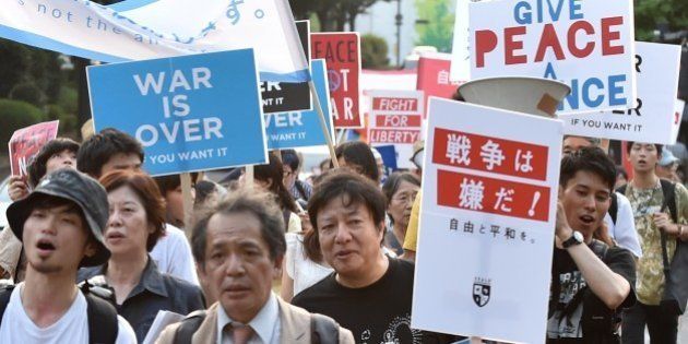Students and scholars stage a demonstration march to protest against controversial security bills which would expand the remit of the country's armed forces, in front of the National Diet in Tokyo on July 31, 2015. The security bills, which Japan's Prime Minister Shinzo Abe and his supporters say are necessary for Japan to deal with the world around it, are deeply unpopular in the country at large. AFP PHOTO / KAZUHIRO NOGI (Photo credit should read KAZUHIRO NOGI/AFP/Getty Images)