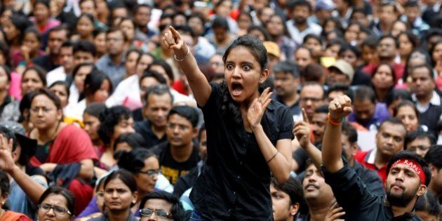 An angry protester points her finger towards the Bangalore police chief during a protest against alleged police inaction after a six-year-old was raped at a school, in Bangalore, India, Saturday, July 19, 2014. More than 4,000 parents and relatives of children who attend the school shouted slogans against the school's administration Saturday and demanded that police arrest those involved in the July 2 incident, which was reported only this past week. (AP Photo/Aijaz Rahi)
