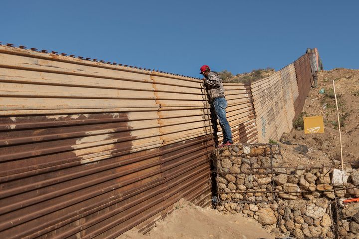A migrant from Honduras looks from the border fence into the U.S. side to San Diego, Calif., from Tijuana, Mexico.