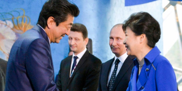 South Korean President Park Geun-hye, right, and Japanese Prime Minister Shinzo Abe, left, shake hands as Russian President Vladimir Putin, second right, watches while visiting an oceanarium on Russky Island where the Eastern Economic Forum takes place in Russian Far Eastern port of Vladivostok, Russia, Saturday, Sept. 3, 2016. (Alexei Druzhinin, Sputnik, Kremlin Pool Photo via AP)