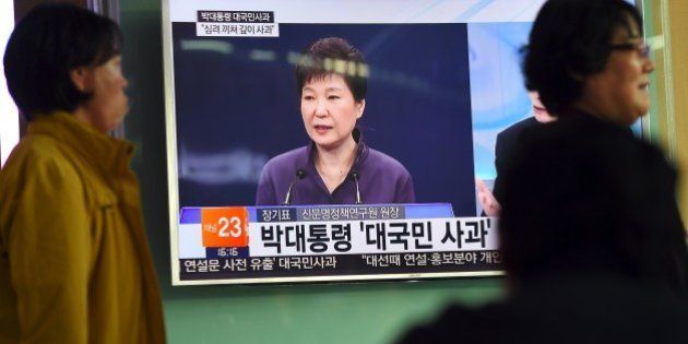 People walk past a television screen showing South Korean President Park Geun-Hye making a public apology, at a railway station in Seoul on October 25, 2016.South Korean President Park Geun-Hye was forced into a public apology on October 25 for the leak of official documents to a family associate involved in a growing corruption scandal. / AFP / JUNG YEON-JE (Photo credit should read JUNG YEON-JE/AFP/Getty Images)