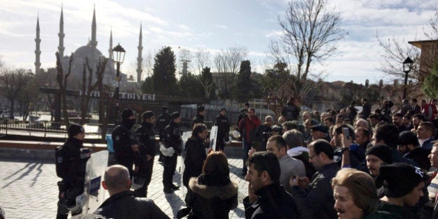 Turkish security members stand near the city's landmark Sultan Ahmed Mosque or Blue Mosque after an explosion at Istanbul's historic Sultanahmet district, which is popular with tourists, on Tuesday, Jan. 12, 2016. The cause of the explosion, which could be heard from several neighborhoods, was not immediately known but TRT said the blast was likely caused by a suicide bomber. Government officials immediately convened for a security meeting, the state-run station said. (IHA via AP) TURKEY OUT