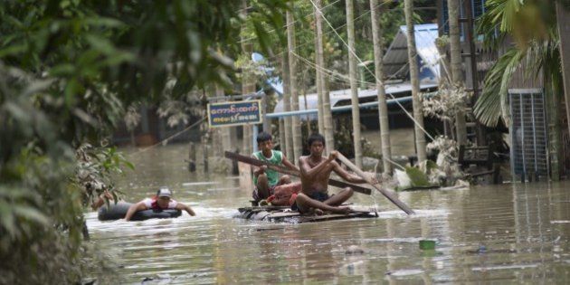 Flood-affected residents use make-shift rafts to travel through floodwaters in Kalay, upper Myanmar's Sagaing region on August 3, 2015. Relentless monsoon rains have triggered flash floods and landslides, destroying thousands of houses, farmland, bridges and roads -- with fast-flowing waters hampering relief efforts. AFP PHOTO / Ye Aung THU (Photo credit should read Ye Aung Thu/AFP/Getty Images)