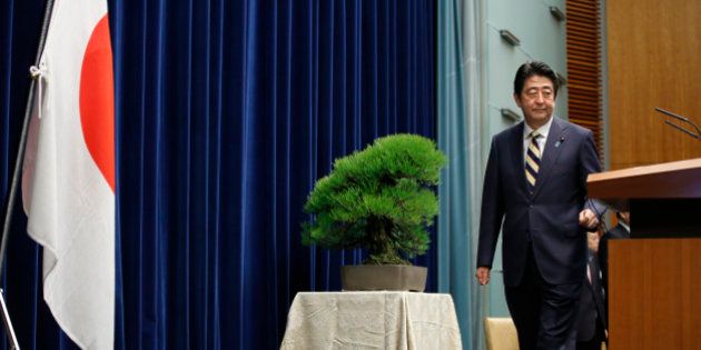 Japanese Prime Minister Shinzo Abe poses to the media before a new year's press conference at his official residence in Tokyo, Monday, Jan. 4, 2016. (AP Photo/Shizuo Kambayashi)