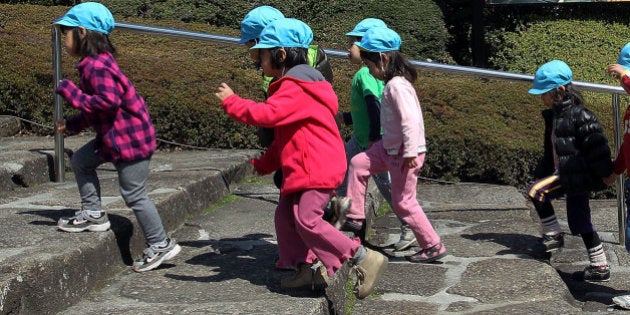 TOKYO - MARCH 30: Japanese Nursery school children visit the Zojoji Temple as cherry trees are in full bloom on March 30, 2010 in Tokyo, Japan. The cherry blossom season draws many locals and visitors alike to viewing festivals around the country. (Photo by Koichi Kamoshida/Getty Images)