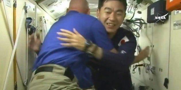 In this image taken from video from NASA, Japanese astronaut Kimiya Yui, right, is greeted as he boards the International Space Station, early Thursday, July 23, 2015. (NASA via AP)