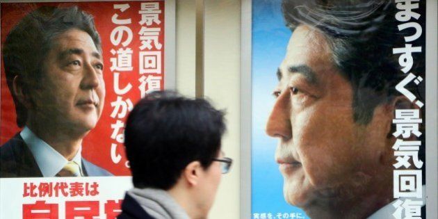 A man walks past posters of Japanese Prime Minister and ruling Liberal Democratic Party (LDP) leader Shinzo Abe displayed at the LDP headquarters in Tokyo on December 4, 2014. Abe's ruling party is set for a landslide win in the December 14 election, according to opinion polls. AFP PHOTO / Yoshikazu TSUNO (Photo credit should read YOSHIKAZU TSUNO/AFP/Getty Images)