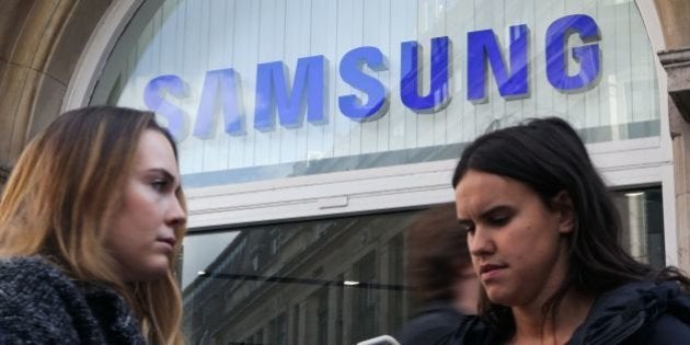 Woman use their smartphones as they stand near a Samsung store in London on October 11, 2016.Samsung suspended all production of its Galaxy Note 7 smartphone, halted sales worldwide and told customers to stop using the device, following reports that replacements for combustible models were also catching fire. / AFP / Daniel Leal-Olivas (Photo credit should read DANIEL LEAL-OLIVAS/AFP/Getty Images)