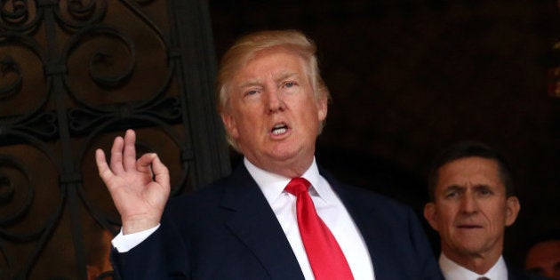 U.S. President-elect Donald Trump talks to members of the media as retired U.S. Army Lieutenant General Michael Flynn stands next to him at Mar-a-Lago estate in Palm Beach, Florida, U.S., December 21, 2016. REUTERS/Carlos Barria