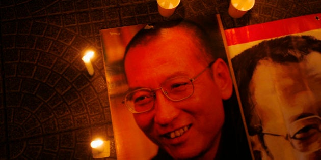 Candles are placed around portraits of jailed Chinese pro-democracy activist Liu Xiaobo during a candlelight vigil demanding his release, outside the Legislative Council in Hong Kong November 2, 2010. It is unclear who will accept the Nobel Peace Prize awarded to jailed Chinese dissident Liu Xiaobo and the Norwegian Nobel Committee may keep custody of it for the time being, its secretary said last week. REUTERS/Bobby Yip (CHINA - Tags: POLITICS CIVIL UNREST)