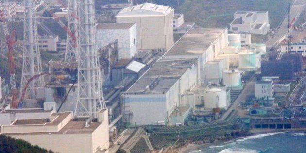 In this aerial photo taken from the Asahi Shimbun helicopter, reactors of the tsunami-stricken Fukushima Dai-ichi nuclear power plant stand in Okuma, Fukushima Prefecture, northeastern Japan, Monday, May 28, 2012. Reactors are, from top center, Unit 1, covered with a beige cover, Unit 2, covered with a light blue cover, Unit 3 and Unit 4, showing their damaged structures surrounded by cranes. The prime minister during Japan's nuclear crisis last year said Monday he had to use an emergency law that never anticipated major radiation leaks and lacked experts capable of giving him guidance. (AP Photo/Tom Curley)