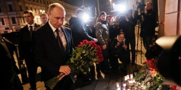 Russian President Vladimir Putin, left, lays flowers at a place near the Tekhnologichesky Institut subway station in St.Petersburg, Russia, Monday, April 3, 2017. A bomb blast tore through a subway train deep under Russia's second-largest city Monday, killing several people and wounding many more in a chaotic scene that left victims sprawled on a smoky platform. (AP Photo/Dmitri Lovetsky)