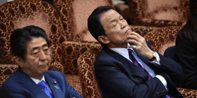 Japanese Prime Minister Shinzo Abe (L) and Finance Minister Taro Aso (R) attend a budget committee session of the House of Councilors at the Parliament in Tokyo on March 24, 2017.A controversial nationalist educator said under oath on March 23 he had received a donation for his school from Prime Minister Shinzo Abe despite the premier's repeated denials in an intensifying political scandal that has gripped the country. / AFP PHOTO / KAZUHIRO NOGI (Photo credit should read KAZUHIRO NOGI/AFP/Getty Images)