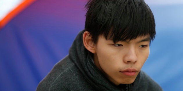 Student leader Joshua Wong sits next to his tent during his hunger strike at the occupied area outside government headquarters in Hong Kong Tuesday, Dec. 2, 2014. A prominent Hong Kong teen protest leader said Monday he's going on a hunger strike after a failed attempt by pro-democracy activists to step up their flagging movement for democratic reforms by surrounding government headquarters. (AP Photo/Kin Cheung)