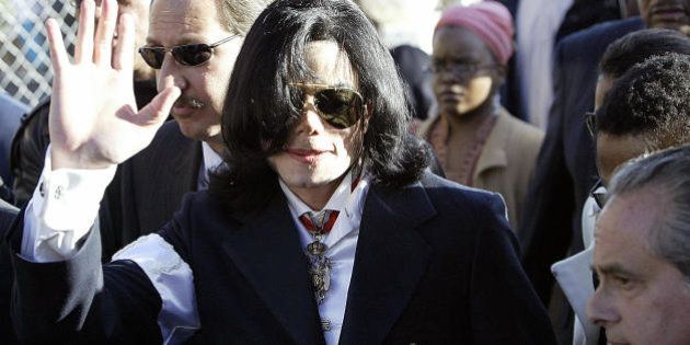 SANTA MARIA, UNITED STATES: Pop star Michael Jackson (C) arrives, with his lawyer Mark Geragos (behing Jackson, glasses) at the courthouse in Santa Maria, California, 16 January, 2004, for his arraignment on child molestation charges. Jackson pleaded not guilty to the charges. AFP PHOTO/HECTOR MATA (Photo credit should read HECTOR MATA/AFP/Getty Images)