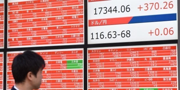 A pedestrian looks at a stock market share prices board in Tokyo on November 18, 2014. Tokyo stocks rose 2.18 percent on a weaker yen and bargain-hunting after tumbling a day earlier in response to data showing the Japanese economy had slumped into recession. AFP PHOTO / KAZUHIRO NOGI (Photo credit should read KAZUHIRO NOGI/AFP/Getty Images)