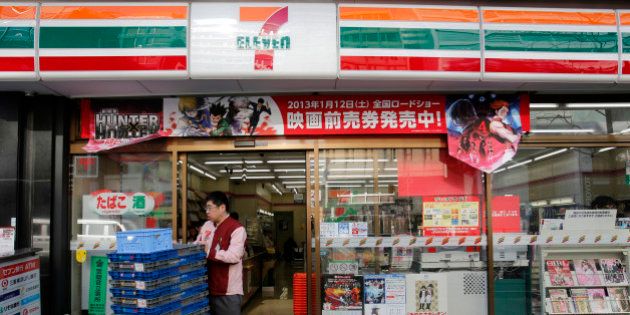 An employee of 7-Eleven works at a convenience store in Tokyo January 8, 2013. Seven & I Holdings Co's quarterly operating profit rose 4.8 percent as higher profits from its 7-Eleven stores helped to offset weaker revenue from other retail formats, leading the Japanese firm to maintain its record annual outlook. REUTERS/Yuriko Nakao (JAPAN - Tags: BUSINESS EMPLOYMENT)