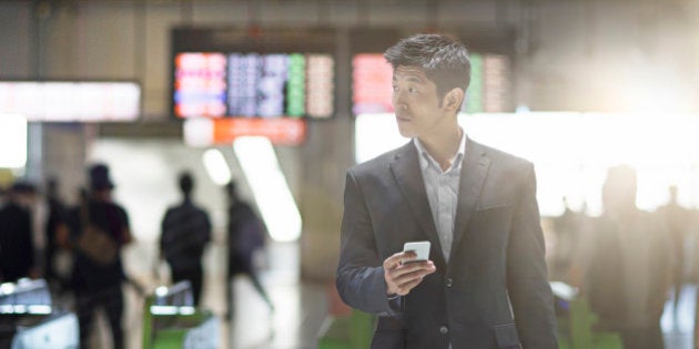 Businessman looking for directions on the mobile phone at Tokyo.