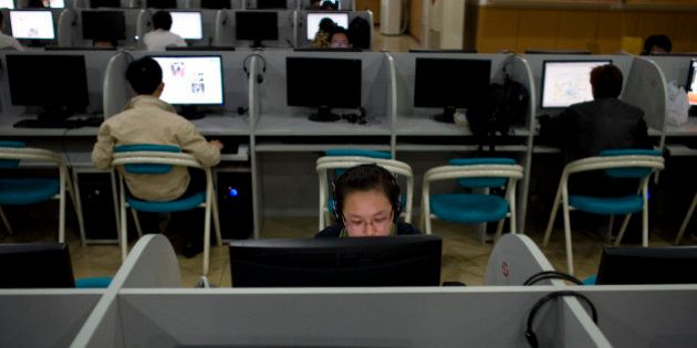 A woman surfs the Internet among others at an Internet cafe in Beijing, China, Thursday, Oct. 29, 2009. The nonprofit body that oversees Internet addresses approved Friday the use of Hebrew, Hindi, Korean, Chinese and other scripts not based on the Latin alphabet in a decision that could make the Web dramatically more inclusive. (AP Photo/Alexander F. Yuan)