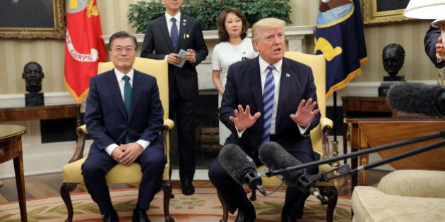 U.S. President Donald Trump reacts after a lamp next to him was almost turned over during a meeting with...