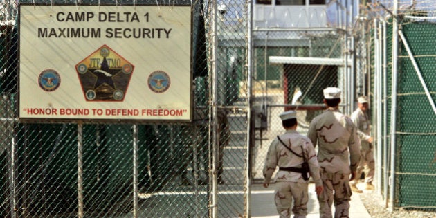 FILE - In this June 27, 2006 file photo, reviewed by a U.S. Department of Defense official, U.S. military guards walk within Camp Delta military-run prison, at the Guantanamo Bay U.S. Naval Base, Cuba. The White House is threatening that President Barack Obama would veto the defense bill unless Congress makes changes. The Office of Management and Budget issued a statement Thursday as the Senate debated the $631 billion bill. Specifically, the White House complained about provisions restricting the administration's ability to transfer detainees from the U.S. Naval facility at Guantanamo Bay, Cuba, to foreign countries. The White House also complained about the prohibition on funds to build a detention facility in the US. (AP Photo/Brennan Linsley, File)