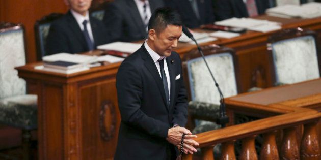 Wearing a black tie, lawmaker Taro Yamamoto of Japan's opposition party