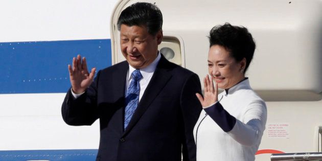 Chinese President Xi Jinping, left, and his wife Peng Liyuan wave upon arrival Tuesday, Sept. 22, 2015, at Boeing Field in Everett, Wash. Xi is spending three days in Seattle before traveling to Washington, D.C., for a White House state dinner on Friday. (AP Photo/Elaine Thompson)