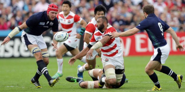 Japan's captain Michael Leitch, centre, throws the ball during the Rugby World Cup Pool B match between Scotland and Japan at Kingsholm, Gloucester, England, Wednesday, Sept. 23, 2015. (AP Photo/Clint Hughes)