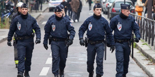 PARIS, FRANCE - JANUARY 07 : Police officers take security measures near the offices of the French satirical newspaper Charlie Hebdo in Paris on January 7, 2015, after armed gunmen attacked the offices leaving twelve dead, including two police officers. (Photo by Geoffroy Van der Hasselt S/Anadolu Agency/Getty Images)