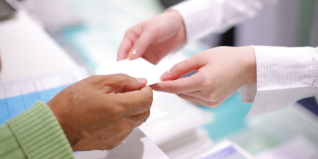 Hands of giving patient's registration ticket