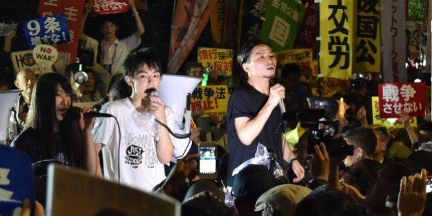 Members of SEALDs (Students Emergency Action for Liberal Democracy - s) stage a rally against Japanese Prime Minister Shinzo Abe's controversial security bills in front of the National Diet in Tokyo on September 18, 2015. Japan was expected to pass security bills on September 18 that would allow troops to fight on foreign soil for the first time since World War II, despite fierce criticism it will fundamentally alter the character of the pacifist nation. AFP PHOTO / KAZUHIRO NOGI (Photo credit should read KAZUHIRO NOGI/AFP/Getty Images)