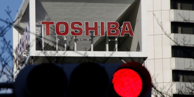 The logo of Toshiba Corp is seen behind a traffic signal at its headquarters in Tokyo, Japan January 27, 2017. REUTERS/Toru Hanai