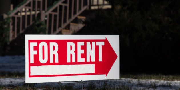Image of a home for rent sign that has a red arrow. Behind the sign is a blurry outline of wooden porch steps. The real estate for rent sign has a blank space for contact information. The yard has light snow on it.